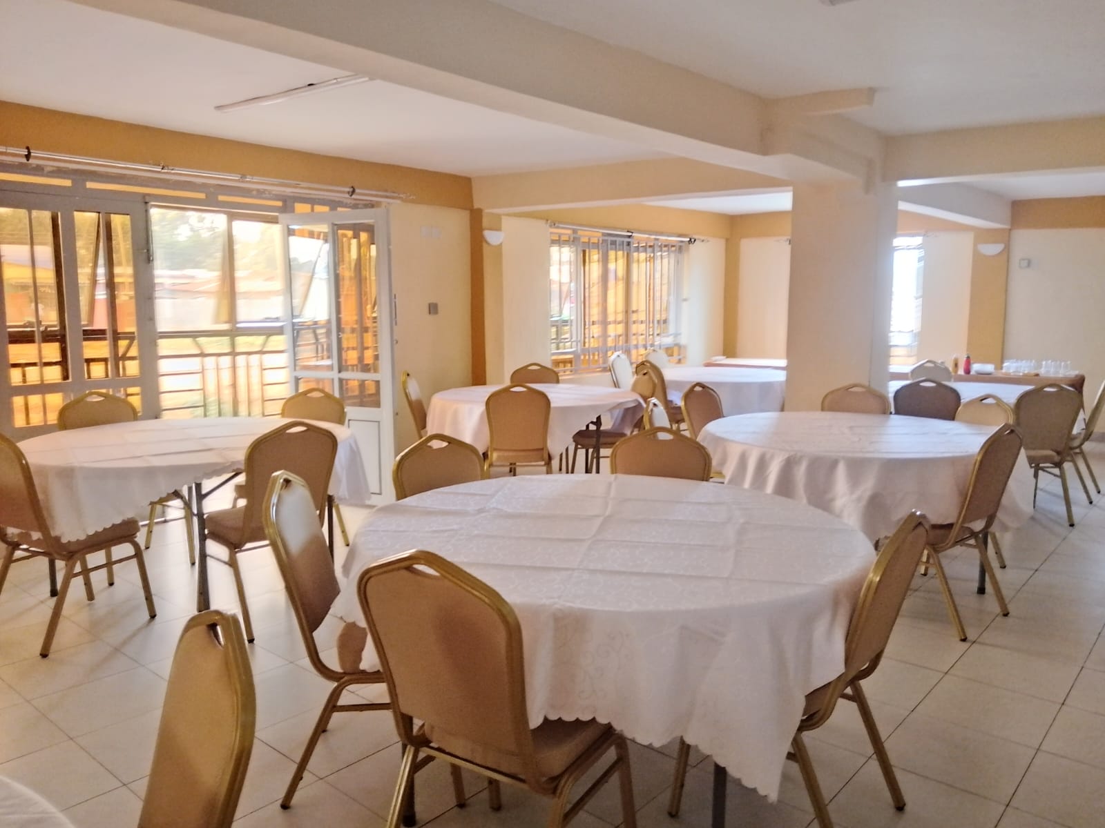 Round tables dressed in white linen ready for a private event at The Ellena Hotel