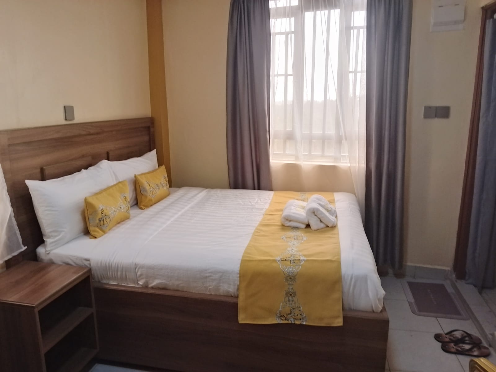 Warm-toned ensuite room with yellow accent cushions