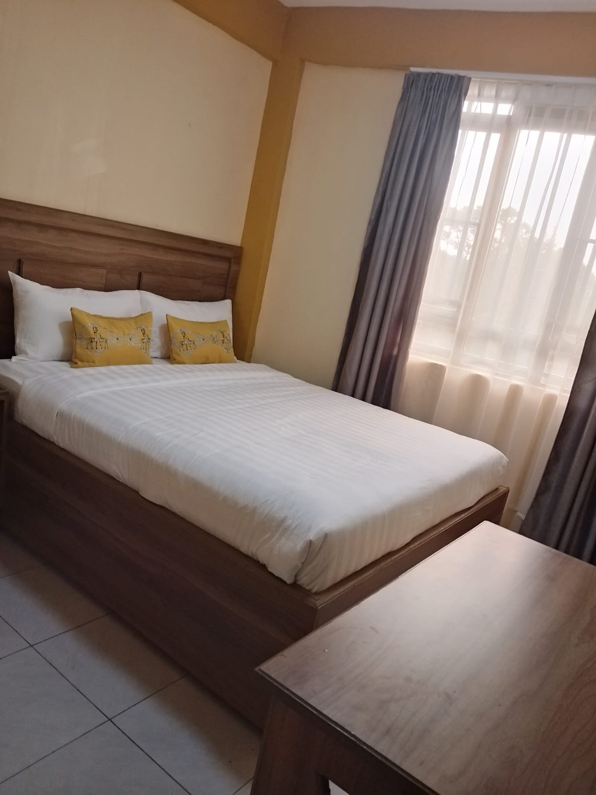 Standard room with wooden headboard and natural light
